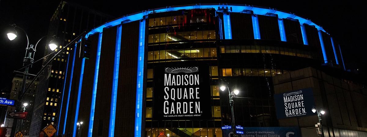 Exterior view of Madison Square Garden arena with blue lighting at night